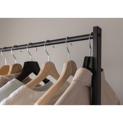 Roupas penduradas em cabides numa barra metálica preta