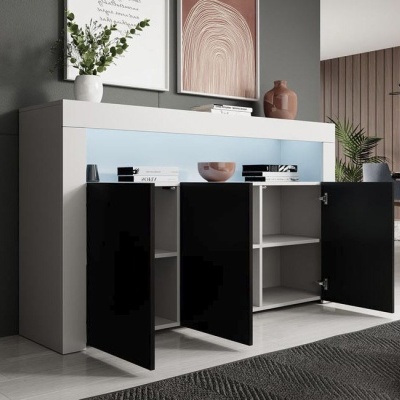 Móvel branco com três portas pretas brilhantes abertas, decorado com vasos e quadros abstratos num ambiente interior