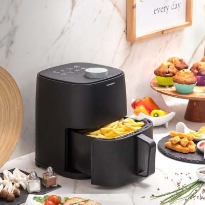 Máquina airfryer preta com batatas fritas numa cozinha moderna
