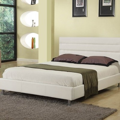 Cama de casal estofada branca com almofadas castanhas numa sala clara