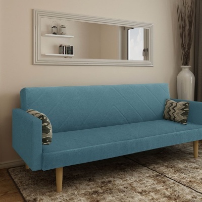 Sofá azul claro com almofadas geométricas em sala com espelho e vaso branco