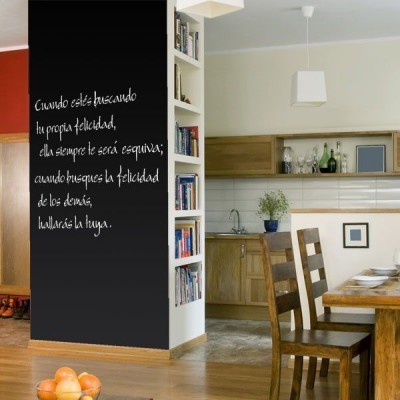 Cozinha e sala de jantar com parede em ardósia preta com mensagem escrita, móveis e cadeiras de madeira