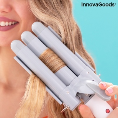 Ferro de modelar cabelo triplo cinzento com três tubos cilíndricos em uso num cabelo loiro.