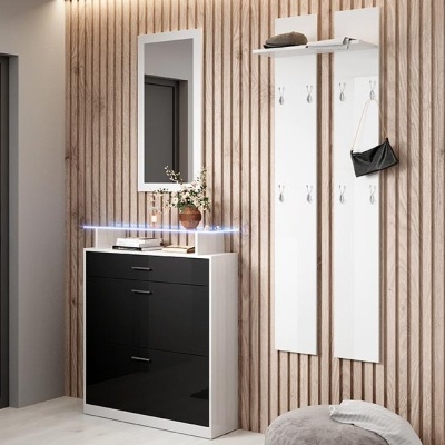 Móvel de entrada com armário branco e preto, espelho, placas brancas com ganchos e parede de ripas de madeira clara.