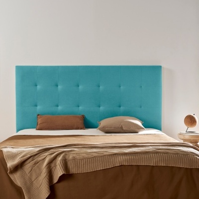 Cama com cabeceira azul turquesa e roupa de cama castanha num quarto iluminado