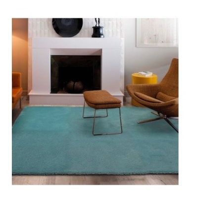 Tapete azul claro com poltrona castanha e lareira branca ao fundo