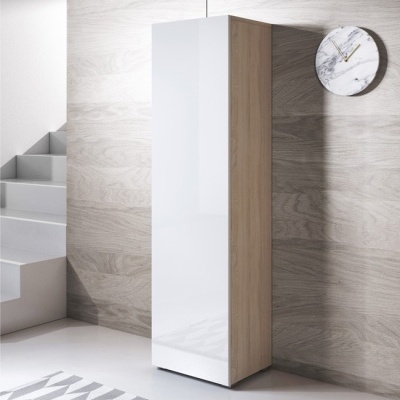 Armário alto de madeira clara com frente branca numa divisão moderna com escada branca e relógio de parede de mármore.