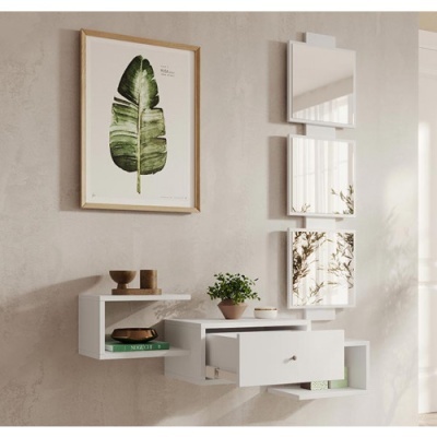 Móvel de parede branco com prateleiras, gaveta, vasos, livro verde, quadro com folha e três espelhos quadrados em parede clara