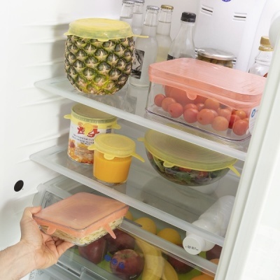 Recipientes de vidro com tampas de silicone coloridas no frigorífico