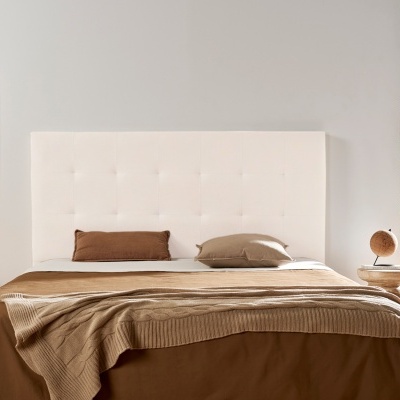 Cama com cabeceira branca estofada, roupa de cama castanha e decoração moderna no quarto