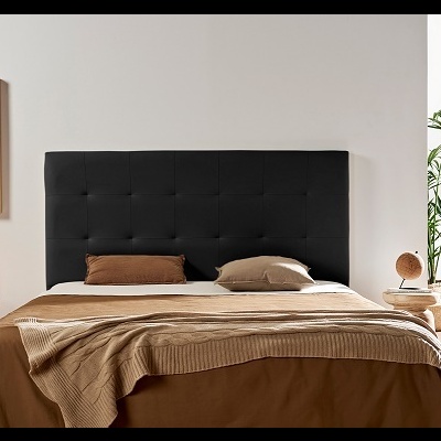 Quarto com cama de casal com cabeceira preta, roupa de cama castanha, almofadas castanhas claras, abajur e planta verde