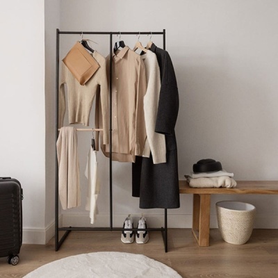 Roupeiro com roupas neutras, sapatilhas, mala e banco com chapéu