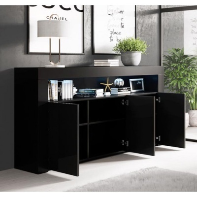 Cómoda preta brilhante com portas abertas, livros, planta e lâmpada em decoração interior moderna