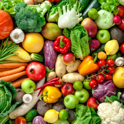 Diversos legumes e frutas frescas coloridas organizadas sobre uma superfície
