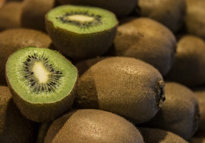 Kiwis inteiros e cortados ao meio com interior verde