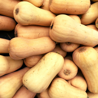 Abóboras butternut amarelas empilhadas numa caixa preta