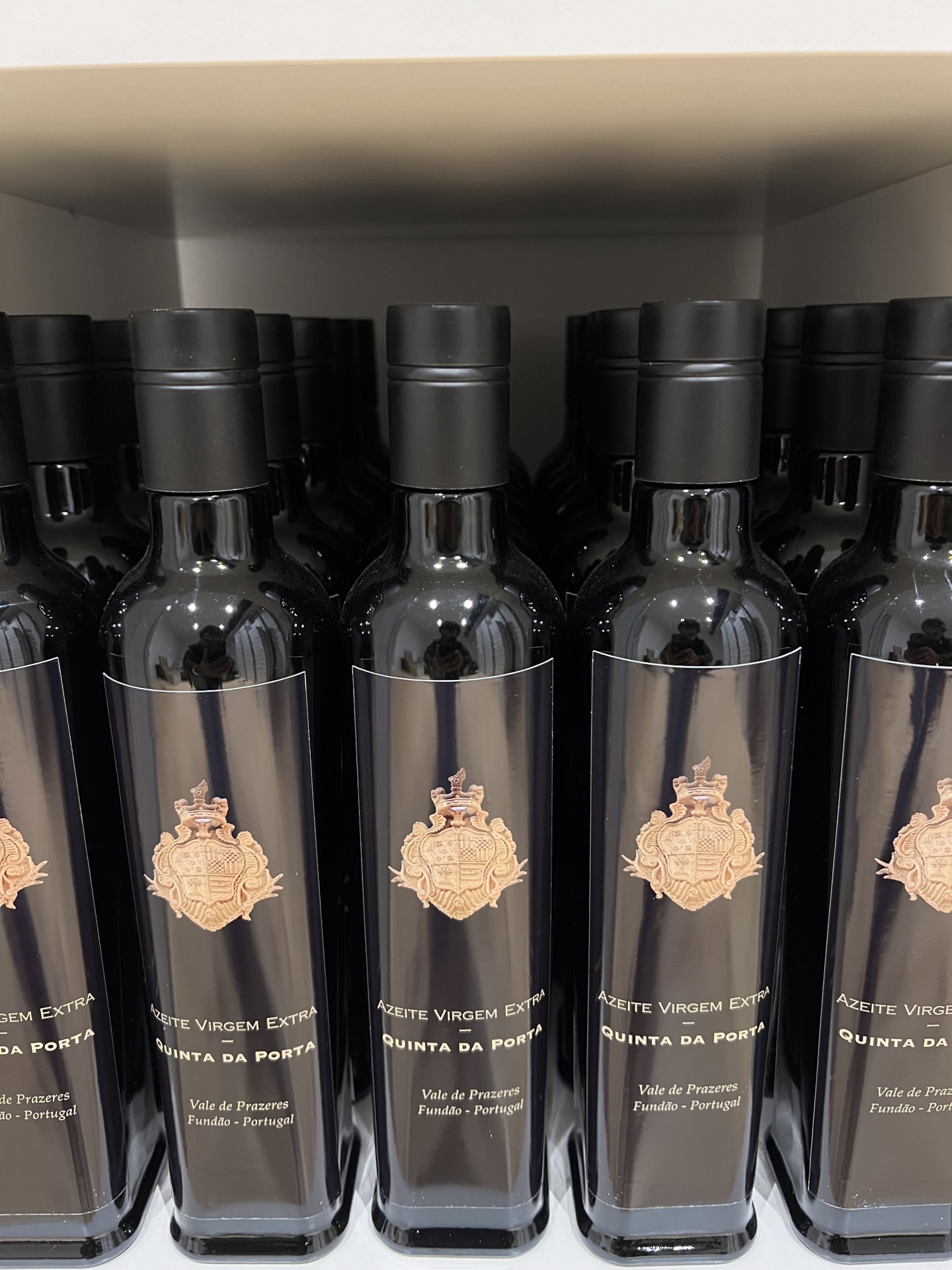 Azeite Virgem Extra - 0,5L Garrafas de azeite virgem extra com rótulo negro e emblema dourado em prateleira
