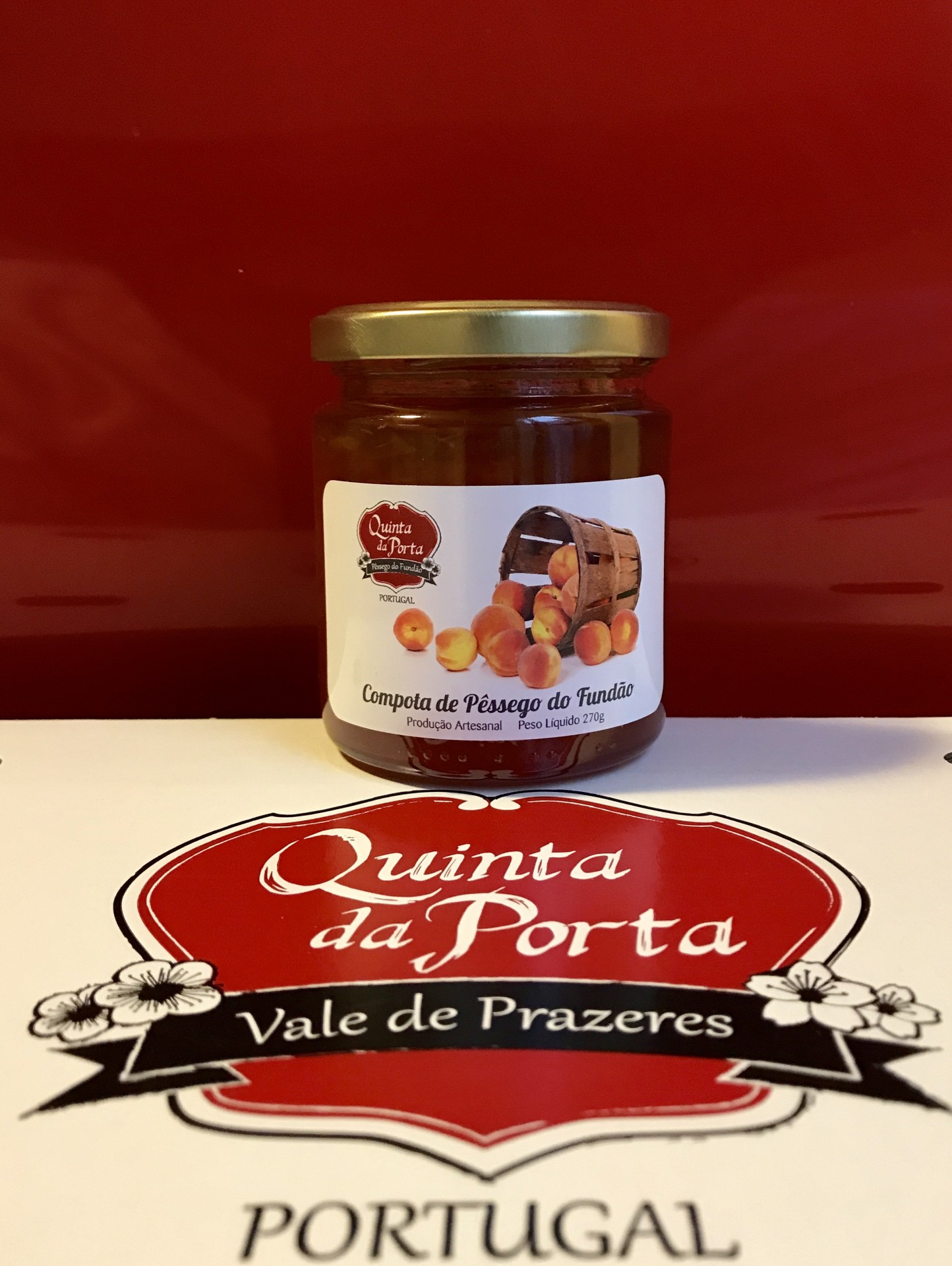 Compota de Pêssego do Fundão Frasco de compota de pêssego com rótulo e logótipo na superfície branca