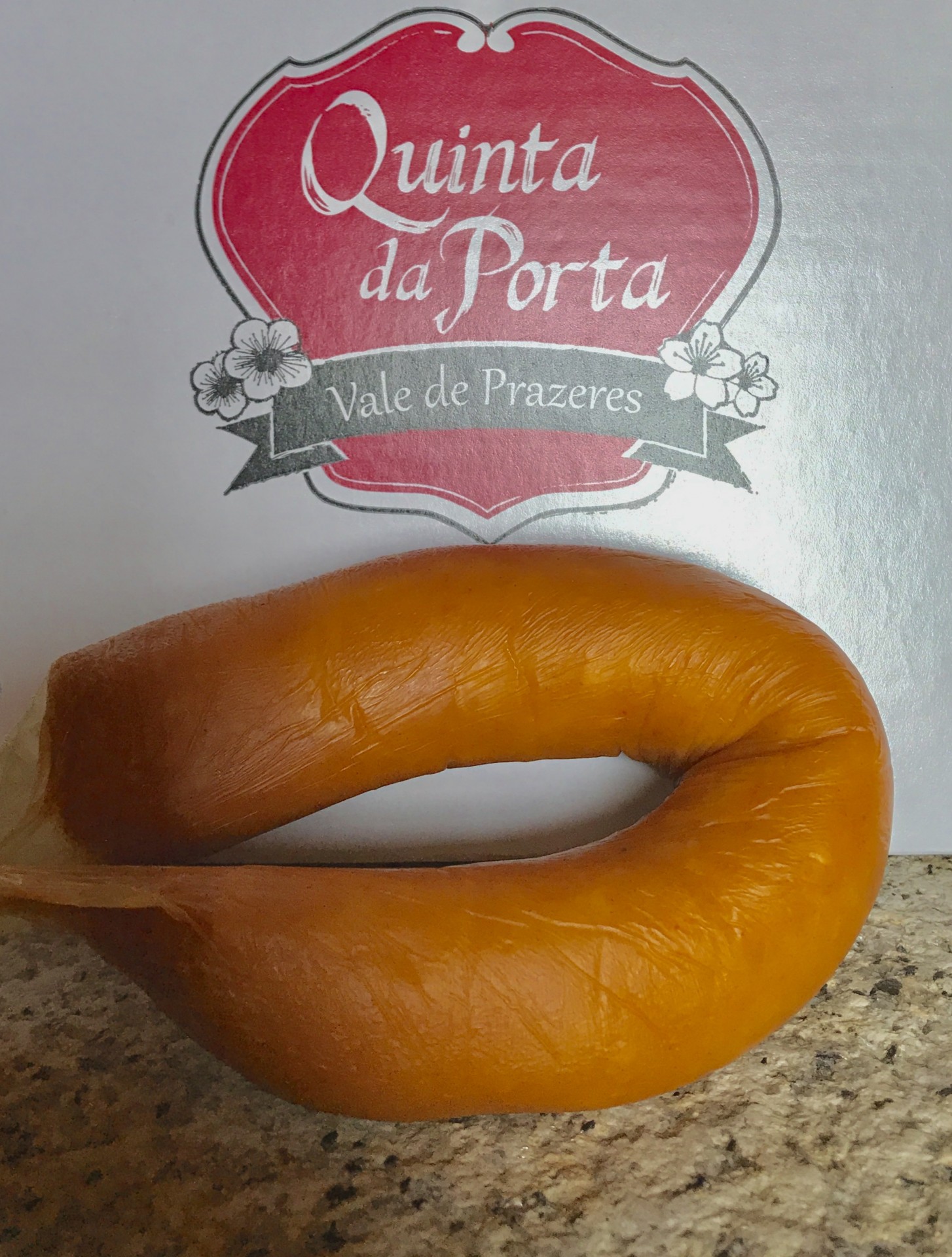 Farinheira da Beira-Baixa (2 un.) Produto alimentar circular alaranjado sobre superfície de pedra com fundo branco e texto 'Quinta da Porta Vale de Prazeres'.