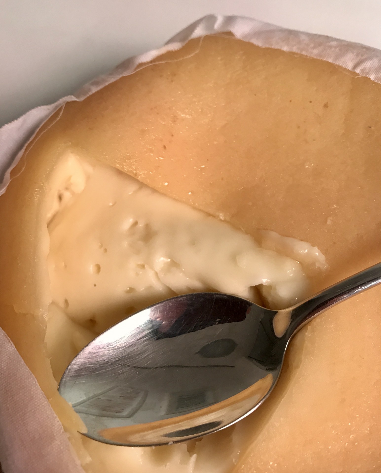 Queijo de Ovelha - Pack 4 Queijos Queijo cremoso amarelo claro em embalagem branca com colher de metal.