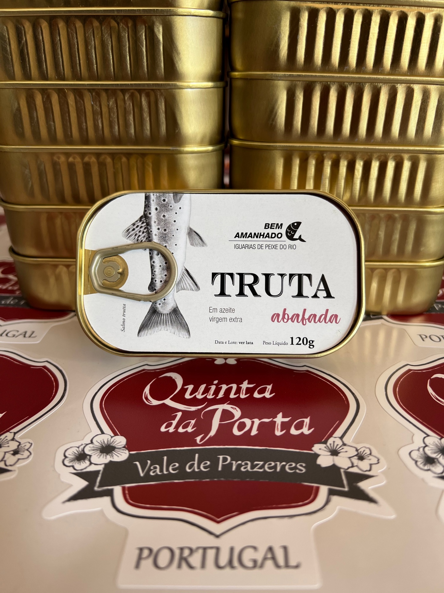 Truta abafada Lata de truta abalada da marca Bem Amanhado sobre superfície com texto Quinta da Porta Vale de Prazeres Portugal