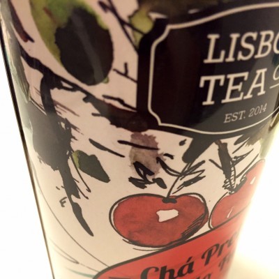 Lata decorada de chá preto com ilustração de cerejas e texto em português.