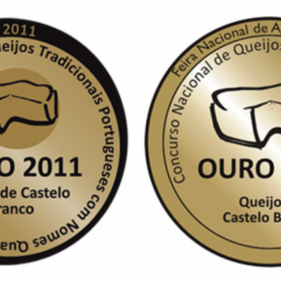 Duas medalhas douradas com inscrições sobre queijo Castelo Branco.
