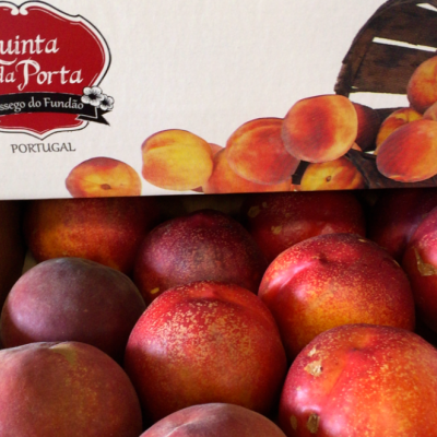 Pêssegos reais com embalagem branca da marca Quinta da Porta e ilustrações de pêssegos e cesto