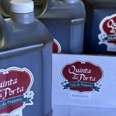 Embalagens plásticas cinzentas com rótulos Quinta da Porta e caixa branca com mesmo logótipo.