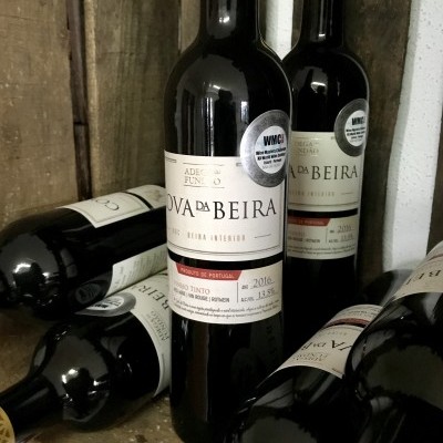 Garrafas de vinho tinto DA BEIRA 2016 com rótulo branco e tampa dourada numa caixa de madeira