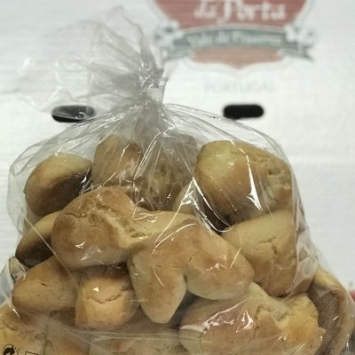 Pacote de biscoitos em plástico transparente com letreiro de vinho ao fundo.