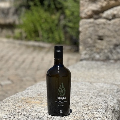 Garrafa de azeite virgem extra FIDORE sobre pedra rústica ao ar livre