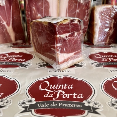 Bloco de carne curada embalado em plástico sobre etiquetas 'Quinta da Porta'