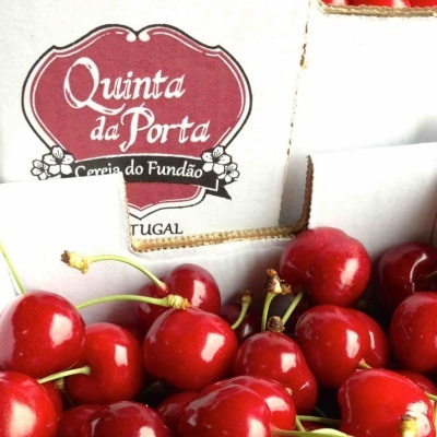 Caixa com cerejas vermelhas brilhantes e etiqueta Quinta da Porta
