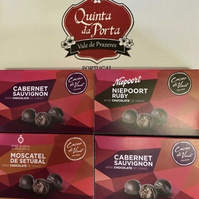 Embalagens de chocolates de vinho com sabores variados e logótipo Quinta da Porta no fundo