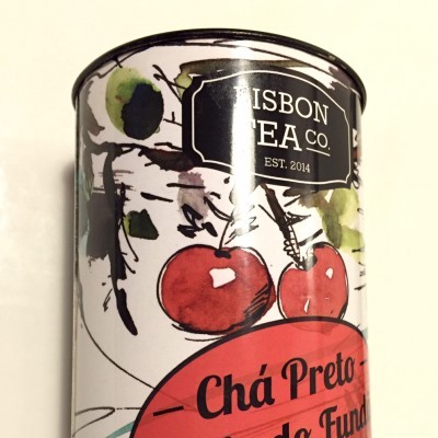 Lata de chá preto com design com cerejas e texto em português