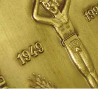 Medalha dourada com figura masculina em relevo e números 1949 e 199