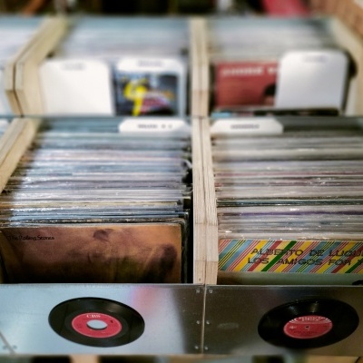 Caixas de madeira com vinis organizados e etiquetas brancas visíveis