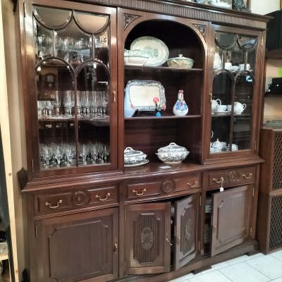 Armário vitrine de madeira escura com vidro e louças expostas
