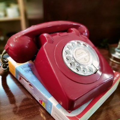 Telefone vintage de disco cor de vinho em cima de livros