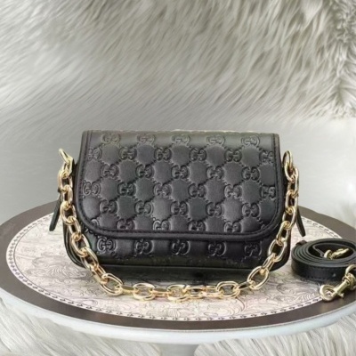 Mala preta de couro com padrão GG e alça de corrente dourada