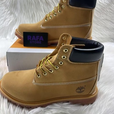 Botas castanhas com gola preta e logo de árvore na lateral