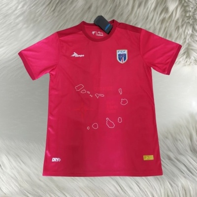 Camisola desportiva vermelha com símbolos e emblemas sobre fundo branco felpudo.