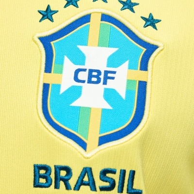 Escudo da selecção brasileira bordado em tecido amarelo com cinco estrelas e palavra BRASIL