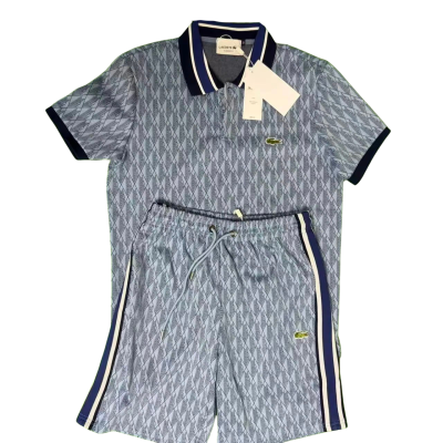 Conjunto polo e calções Lacoste azul com padrão geométrico e logo verde crocodilo