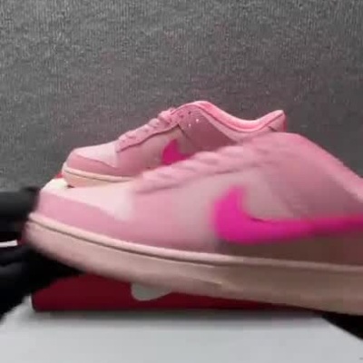 Par de sapatilhas Nike rosas com pormenores fúcsia sobre caixa vermelha