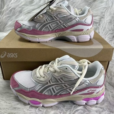 Ténis Asics em branco, rosa e cinzento, sobre caixa e superfície felpuda branca