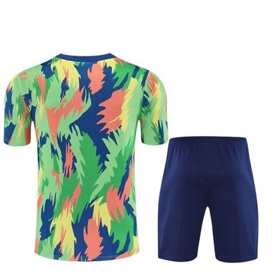 Conjunto desportivo com camisola colorida e calções azul escuro.