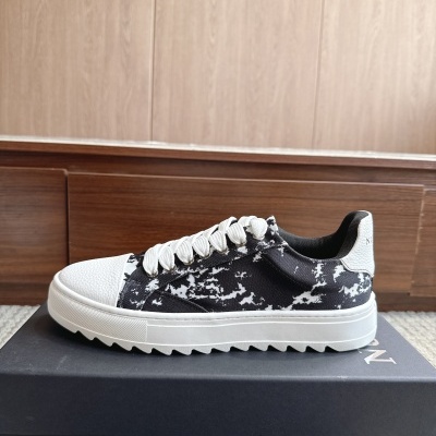 Ténis preto e branco com padrão, atacadores brancos, biqueira e calcanhar brancos texturizados sobre caixa preta