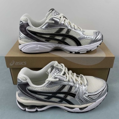 Sapatilhas de corrida Asics brancas, pretas e prateadas sobre uma caixa de cartão castanha.